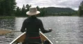 Woman paddles canoe. Sunny water. POV from stern. HD Footage