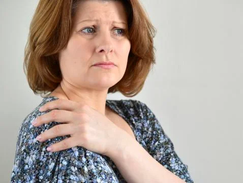 Woman with pain in his shoulder on light background Stock Photos