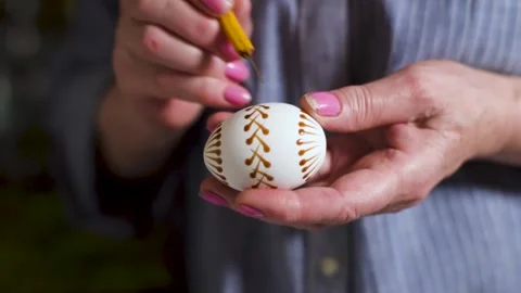 Woman paint Easter eggs in an authentic way with wax candles and paint. Home Stock Footage 131018257