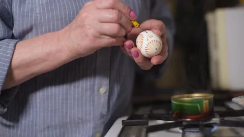 Woman paint Easter eggs in an authentic way with wax candles and paint. Home Stock Footage 131021523