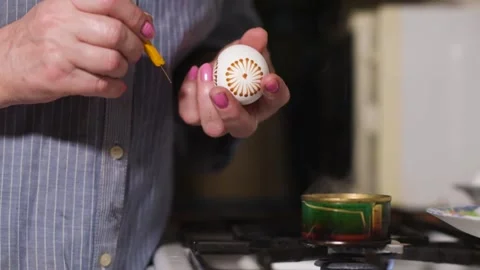 Woman paint Easter eggs in an authentic way with wax candles and paint. Home Stock Footage 131053010