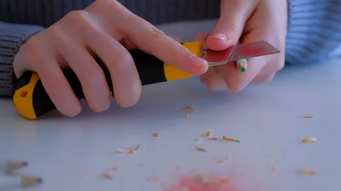 Woman painter artist sharpening pencil using sharp knife, hands closeup. Stock Footage 128749341