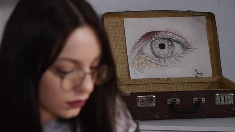 Woman painter is working on a sketch while sitting in her office. She is wearing Stock Footage 74271463