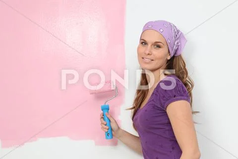 Woman painting baby nursery pink Stock Photos