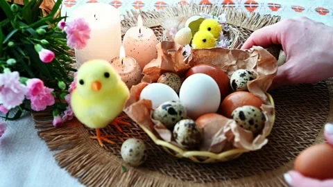 Woman painting Easter eggs with yellow paint on festive table. Stock Footage 329052670