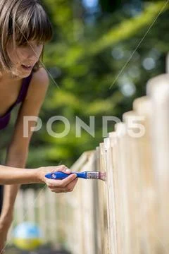 Woman painting a garden fence Stock Photos