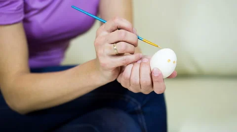 Woman paints on Easter egg Stock Footage 60820209