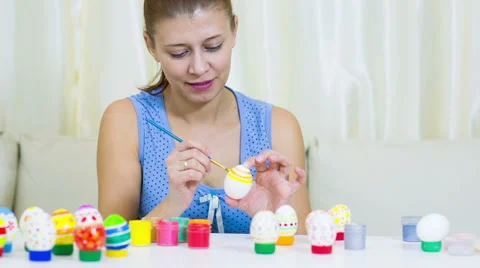Woman paints on Easter egg Видео 60823140