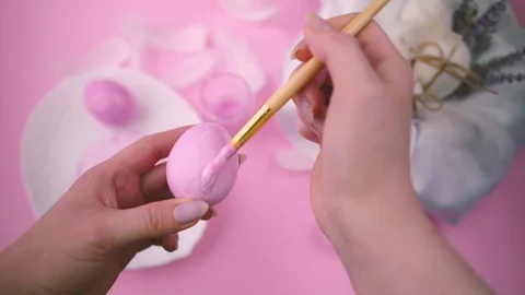 Woman paints Easter eggs with a brush in pink. Stock Footage 122320862
