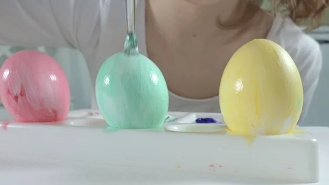 A woman paints Easter eggs with colored paints, close-up Video stock 86525998
