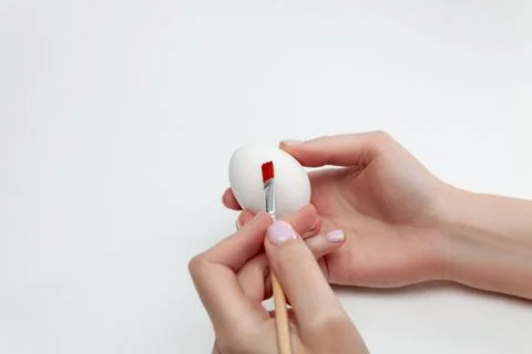 A woman paints Easter eggs in preparation for the holidays. Stock Photos