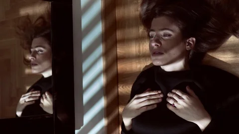 Woman with  A Panic Attack lying on the floor in the dark Stock Footage 86332395