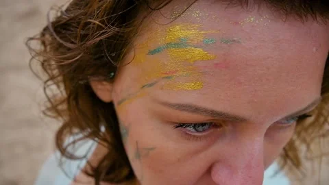 A woman with a pattern on her face, applied with special bright body paints Stock Footage 163152698