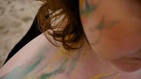 A woman with a pattern on her face, applied with special bright body paints Stock Footage 163293132