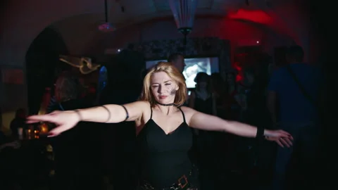 Woman with a pattern on her face dances incendiarily in a nightclub at a party Stock Footage 204945854