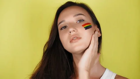 Woman with a pattern of a rainbow on her face close-up. Vídeo Stock 137889153