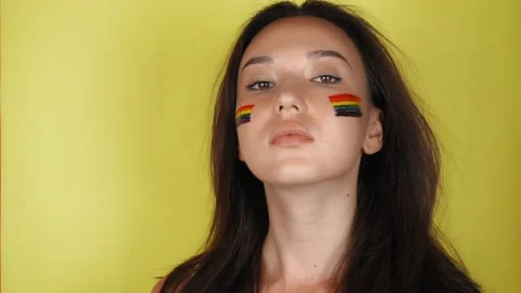 Woman with a pattern of a rainbow on her face close-up. Vídeo Stock 137889193