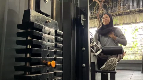Woman pausing by a heavy weight stack in a gym. Stock Footage 346014640