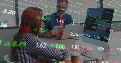 Woman pausing while man lifting tablet, both reviewing live stock tickers over 스톡 사진