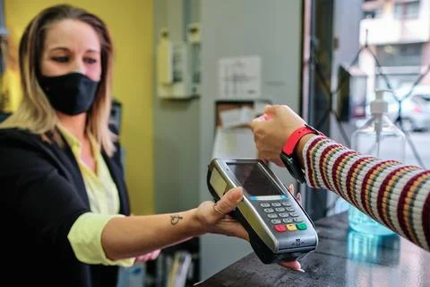 A woman pay using smartwatch using contactless technology - new normal Stock Photos