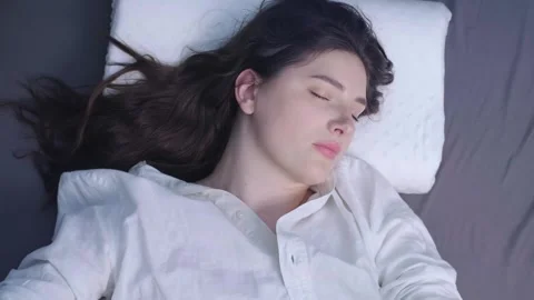 Woman peacefully sleeping on a comfortable memory foam pillow, reducing the risk Stock Footage 299722361