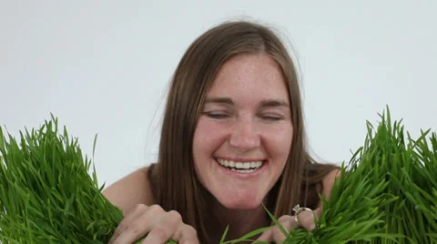 Woman peeks out of grass patch Stock Footage 32716270