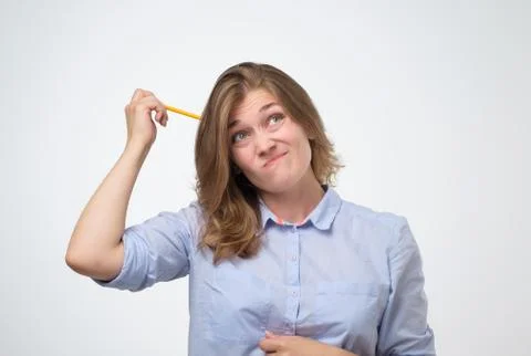 Woman with pencil thinking how to solve a problem Stockfoto's