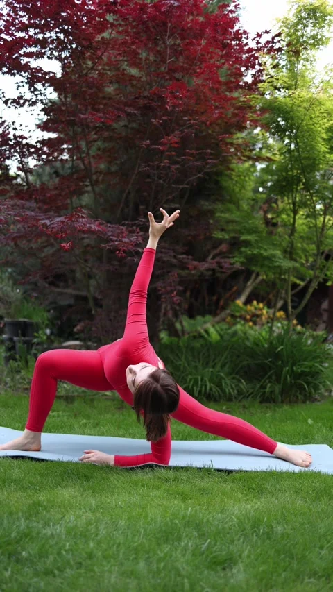 Woman performing advanced side plank outdoors Stockbeeldmateriaal 336529194
