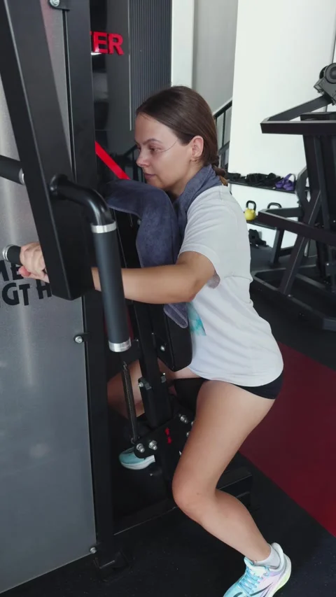 Woman performing chest fly exercise on a machine, focusing on strength training Stock Footage 340959351