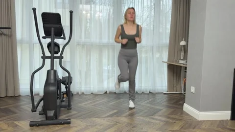 Woman performing controlled cardio steps with knees and arms coordination at Stock Footage 345686667