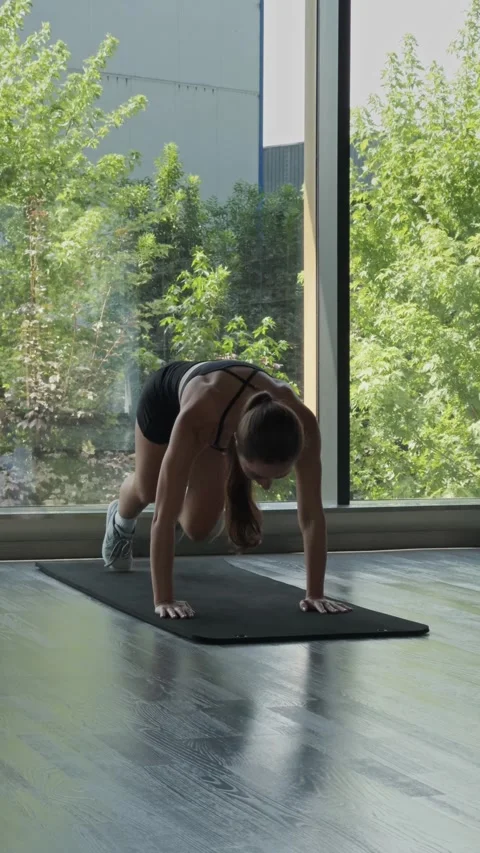 Woman performing a mountain climber exercise on a mat, training indoors Stock Footage 339599569