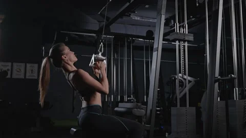 A woman is performing pull ups on a machine at the gym Stock Footage 266920908