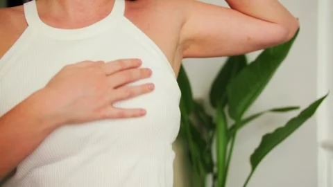 Woman is performing a self-examination, checking breasts by palpation to feel Stock Footage 324519229