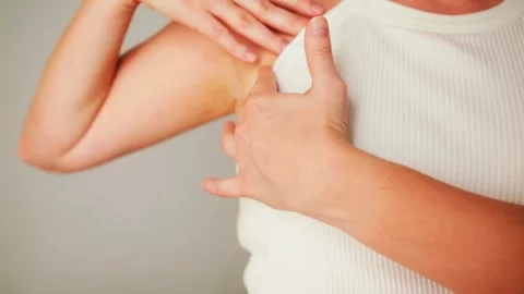Woman is performing a self-examination, checking breasts by palpation to feel Stock Footage 326903665