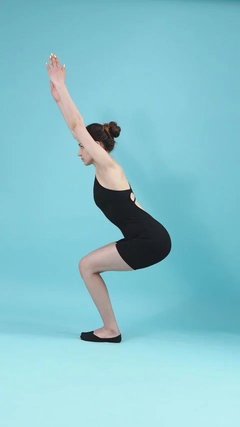 Woman Performing Squats Exercise Side View on Blue Background Stockbeeldmateriaal 345538700