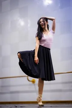 Woman performs ballet dance in studio during afternoon with soft lighting and Stock Photos