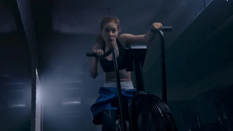 Woman performs cardio exercise on an exercise bike at the gym Stock Footage 277345263