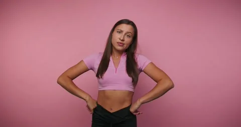 Woman performs a routine with hand movements in front of a pink background .. Stock-Footage 331990317
