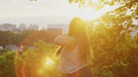 A woman performs a sensual dance in the rays of the sun against. Vídeos de archivo 243009982