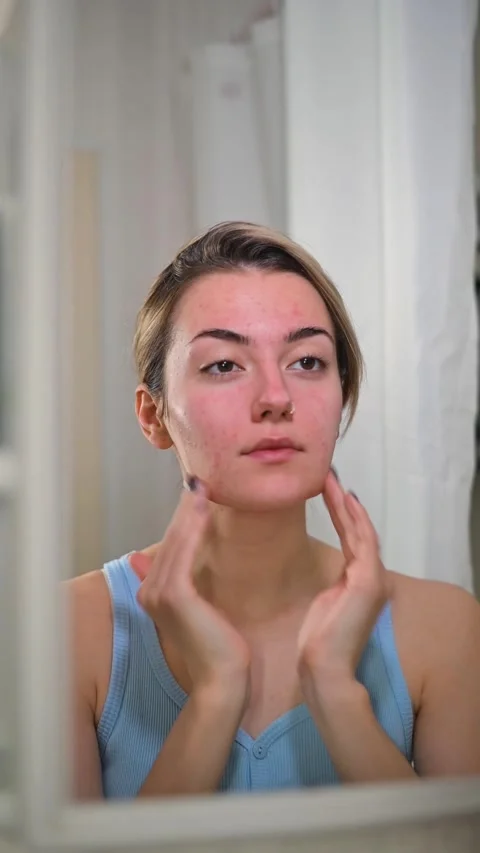 A woman performs a skincare routine in front of a mirror. She applies products Stock Footage 337112749