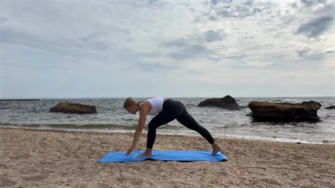Woman performs yoga pose on beach. Concept of wellness and spiritual balance Stock-Footage 337220053
