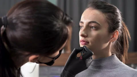 Woman with permanent makeup on her lips in a beauty salon. A cosmetologist in Stock Footage 171363076