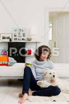 Woman Petting Dog In Living Room