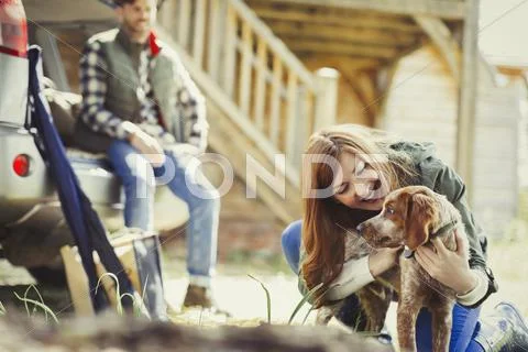 Woman petting dog outside cabin Stock Photos