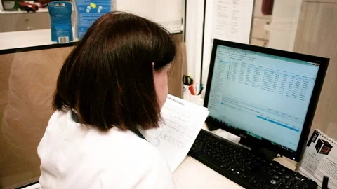 Woman pharmacist in a pharmacy looks at the computer a list of medicines. Stock Footage