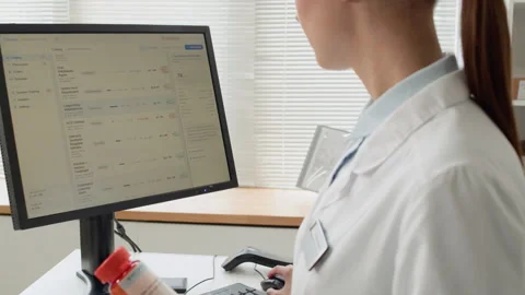 Woman Pharmacist using Computer in Pharmacy Stock Footage 334863281