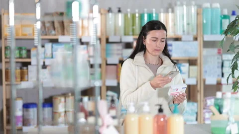 Woman in pharmacy scans QR code on paracetamol Stock Footage 309526182