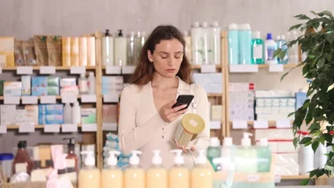 Woman in pharmacy scans QR code on baby formula product Stock Footage 316577014