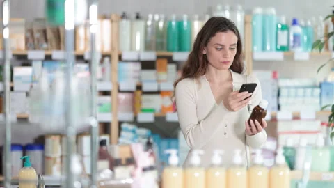 Woman in pharmacy scans QR code on antitussive syrup product Stock Footage 317140469