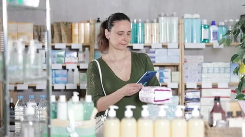 Woman in pharmacy scans QR code on feminine pads Stock Footage 325031445